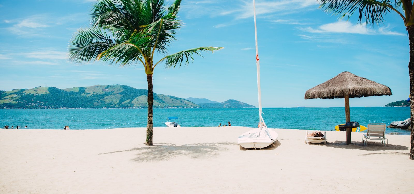 Palm-lined white sand beach with clear turquoise lagoon